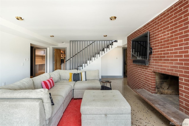 living area featuring stairs, baseboards, speckled floor, a fireplace, and brick wall
