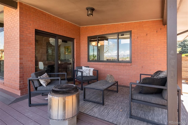 wooden terrace featuring an outdoor living space with a fire pit