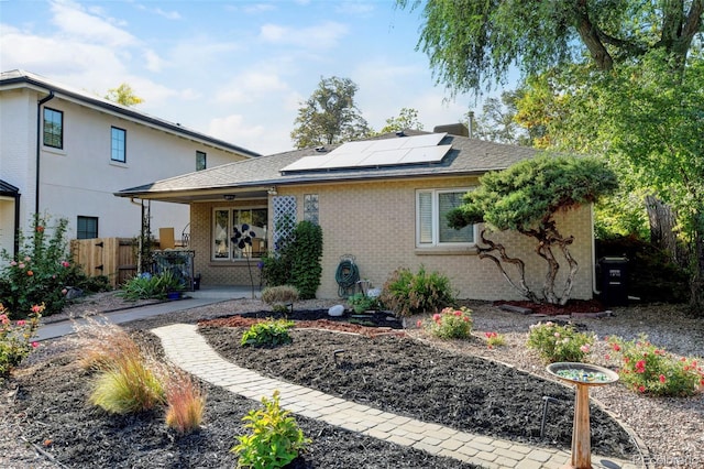 1275 Fairfax St, Denver, CO 80220 - view of front facade featuring brick siding, roof mounted solar panels, and roof with shingles