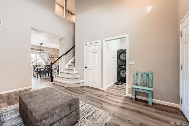 12362 Nate Cir, Parker, CO 80134 - entrance foyer featuring stacked washing machine and dryer, wood finished floors, a towering ceiling, stairway, and a chandelier