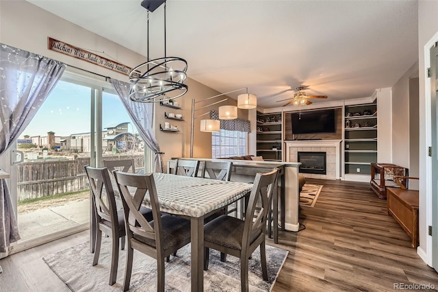 12362 Nate Cir, Parker, CO 80134 - dining area with a ceiling fan, a tile fireplace, wood finished floors, and a chandelier