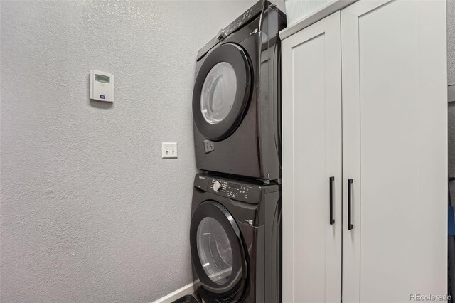 12362 Nate Cir, Parker, CO 80134 - laundry area with stacked washer / dryer, a textured wall, and baseboards
