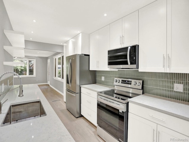 2046 S Quitman St, Denver, CO 80219 - kitchen featuring stainless steel appliances, light wood-style flooring, white cabinets, and recessed lighting