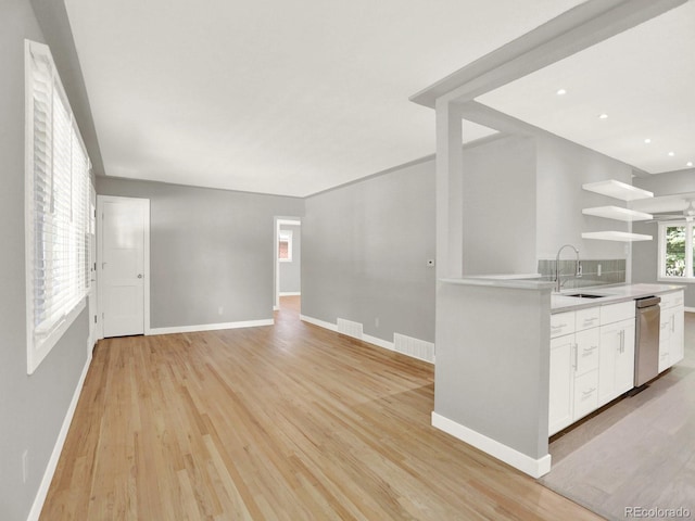 2046 S Quitman St, Denver, CO 80219 - kitchen with white cabinetry, open shelves, light countertops, light wood-type flooring, and dishwasher