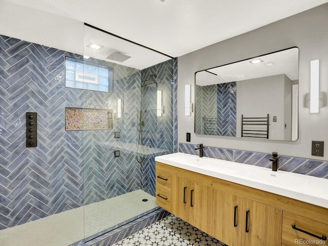 2046 S Quitman St, Denver, CO 80219 - full bath featuring double vanity, a stall shower, a towel warmer, and tile walls