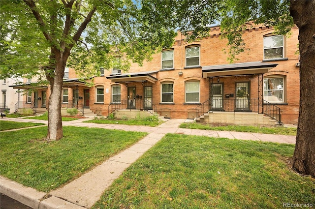 709 27th St, Denver, CO 80205 - view of property with brick siding, a front yard, and covered porch