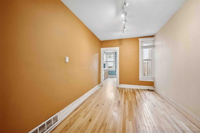 709 27th St, Denver, CO 80205 - unfurnished room featuring baseboards, light wood-style floors, and rail lighting