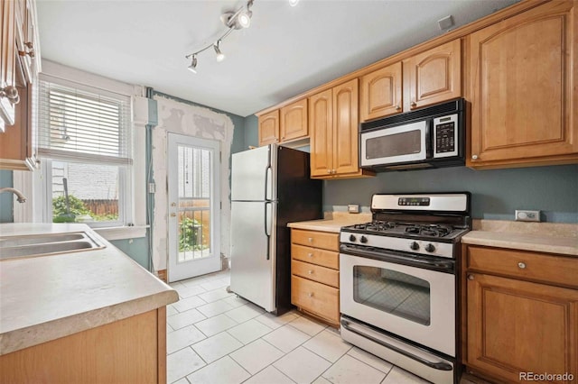 709 27th St, Denver, CO 80205 - kitchen with appliances with stainless steel finishes, a sink, light countertops, light tile patterned floors, and track lighting