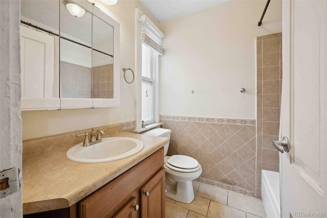 709 27th St, Denver, CO 80205 - bathroom featuring tile walls, vanity, tile patterned flooring, toilet, and washtub / shower combination