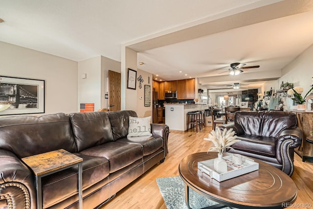 living room with light hardwood / wood-style flooring and ceiling fan