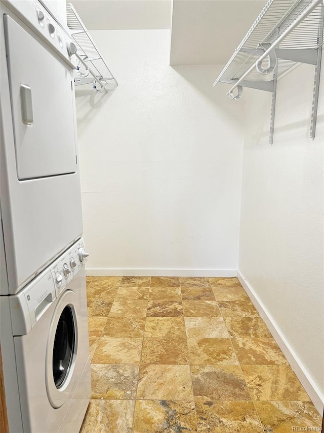 611 E 7th Ave, Denver, CO 80203 - washroom with laundry area, baseboards, stone finish flooring, and stacked washer / drying machine