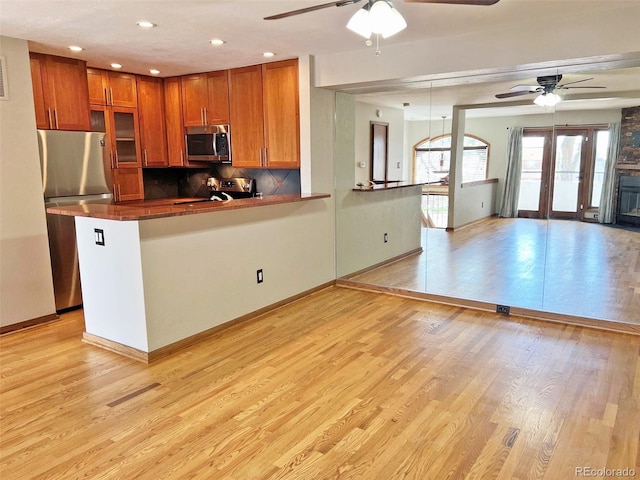611 E 7th Ave, Denver, CO 80203 - kitchen featuring brown cabinetry, a ceiling fan, and stainless steel appliances