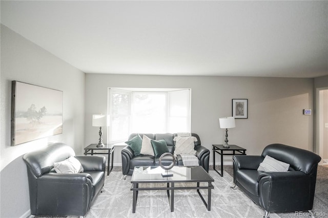 living area featuring baseboards and light colored carpet