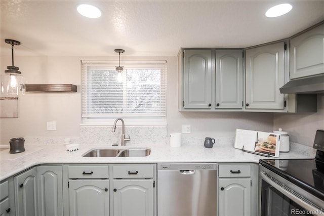 kitchen with a sink, light countertops, pendant lighting, and stainless steel appliances