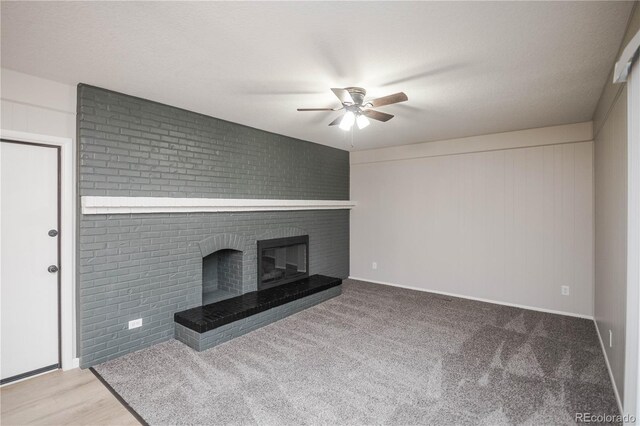 unfurnished living room with a brick fireplace and ceiling fan