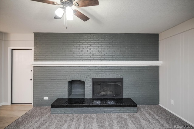 room details featuring a textured ceiling, ceiling fan, and a fireplace