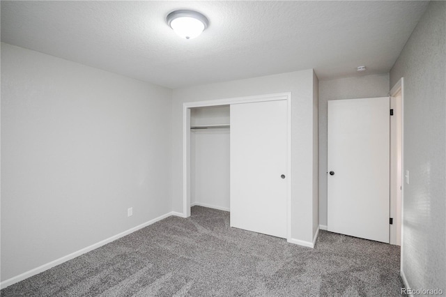 unfurnished bedroom featuring a closet, baseboards, a textured ceiling, and carpet