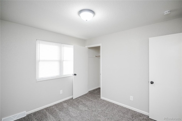 unfurnished bedroom featuring visible vents, carpet flooring, and baseboards