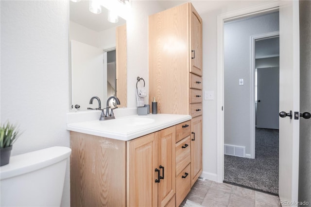 bathroom with visible vents, toilet, vanity, and baseboards