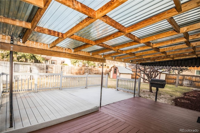 wooden terrace with a fenced backyard, a storage shed, and an outdoor structure