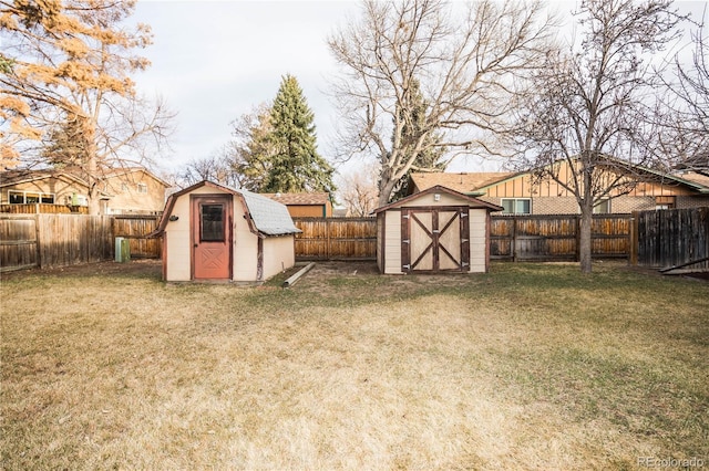 view of yard with an outdoor structure, a fenced backyard, and a shed