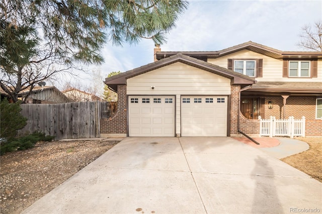 view of front of home with concrete driveway, an attached garage, fence, and brick siding