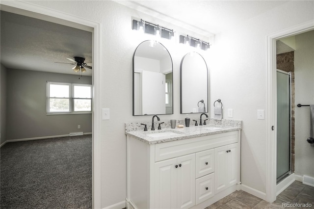 1409 S Moline St, Aurora, CO 80012 - full bathroom with ceiling fan, double vanity, a shower stall, and baseboards