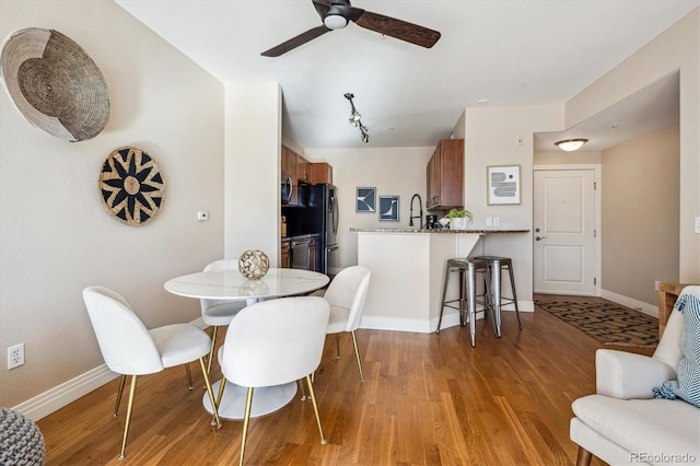 dining room with light hardwood / wood-style floors, ceiling fan, and sink