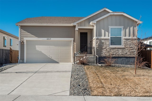 ranch-style house featuring a garage, concrete driveway, stone siding, fence, and board and batten siding