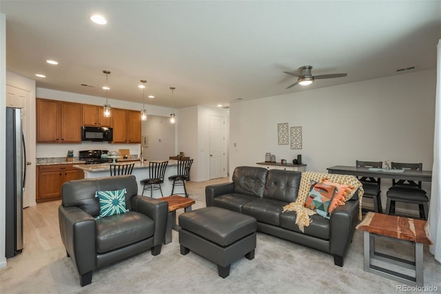 living area with ceiling fan, visible vents, and recessed lighting