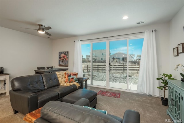 living area with carpet and a ceiling fan