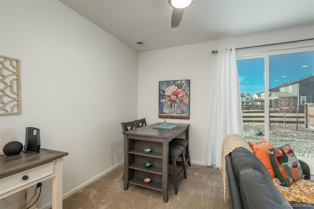 carpeted office space with ceiling fan, visible vents, and baseboards