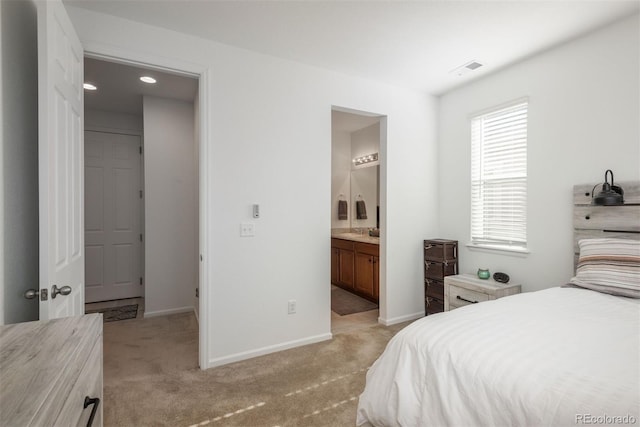 bedroom with light carpet, visible vents, baseboards, and connected bathroom