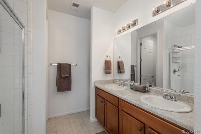 full bathroom featuring double vanity, a shower stall, a sink, and tile patterned floors