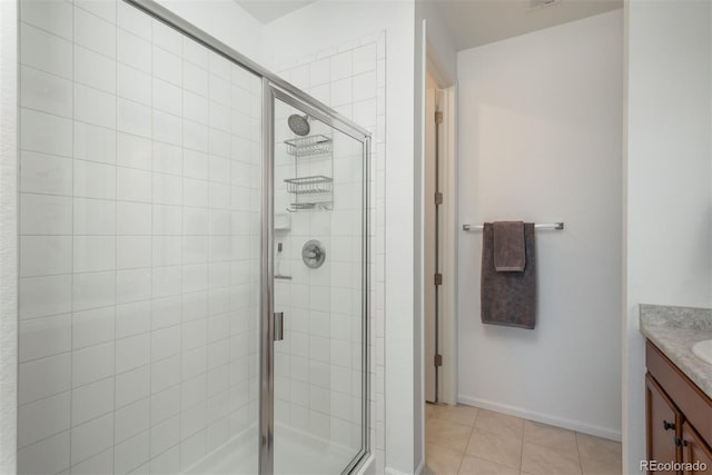 bathroom featuring baseboards, a stall shower, vanity, and tile patterned floors