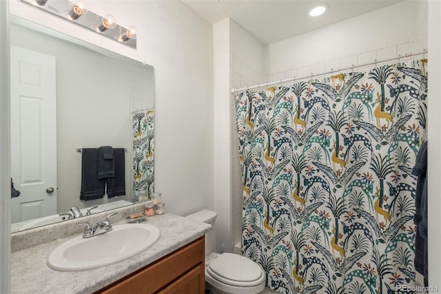 bathroom featuring toilet, a shower with shower curtain, and vanity