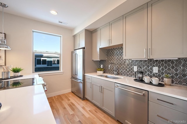 kitchen featuring sink, gray cabinetry, hanging light fixtures, appliances with stainless steel finishes, and decorative backsplash