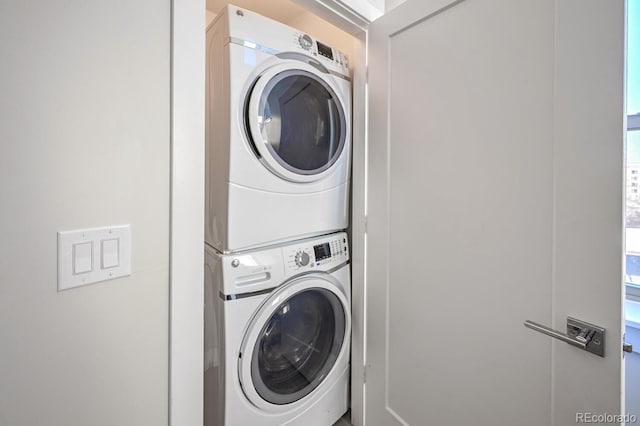 clothes washing area with stacked washer and clothes dryer