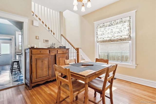 dining area featuring stairway, plenty of natural light, light wood-style flooring, and baseboards