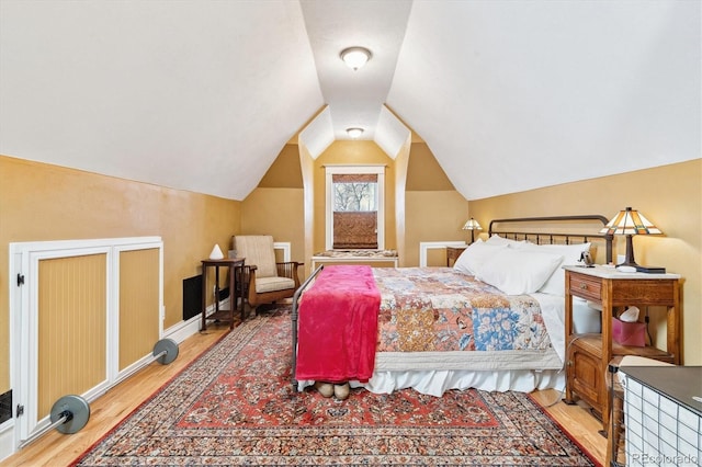 bedroom featuring light wood-style flooring and vaulted ceiling