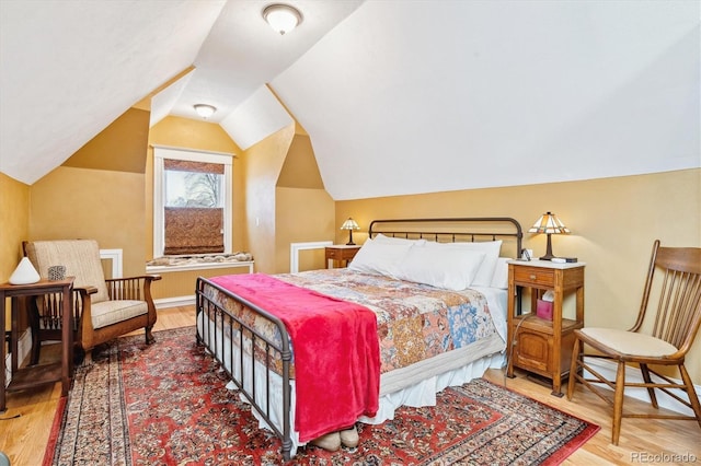 bedroom featuring vaulted ceiling, wood finished floors, and baseboards