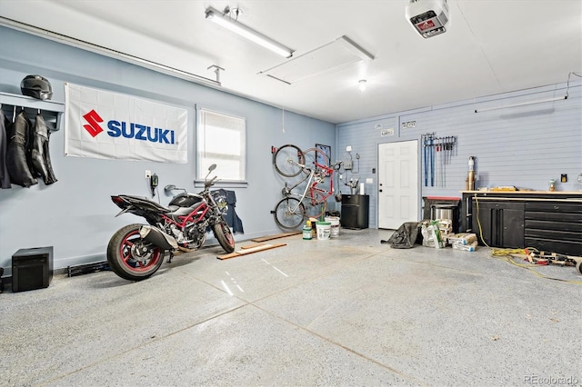 garage featuring a workshop area, a garage door opener, and baseboards