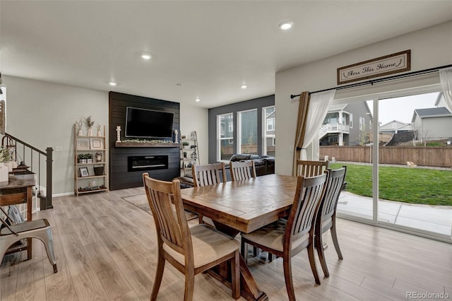 dining room featuring a fireplace and light wood-type flooring