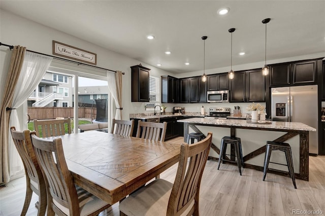 dining area with sink and light wood-type flooring