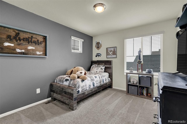 bedroom featuring light colored carpet and multiple windows