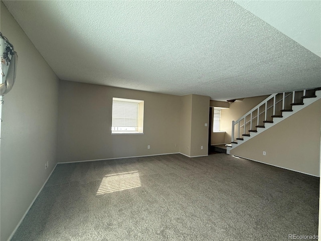 unfurnished living room featuring plenty of natural light, a textured ceiling, and carpet flooring