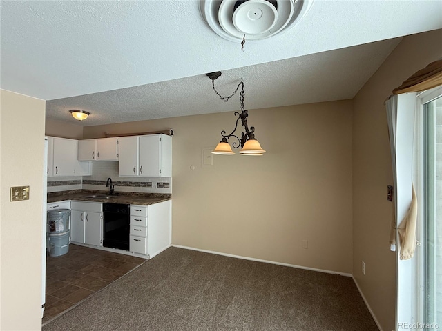 kitchen featuring sink, white cabinets, decorative backsplash, hanging light fixtures, and dark carpet