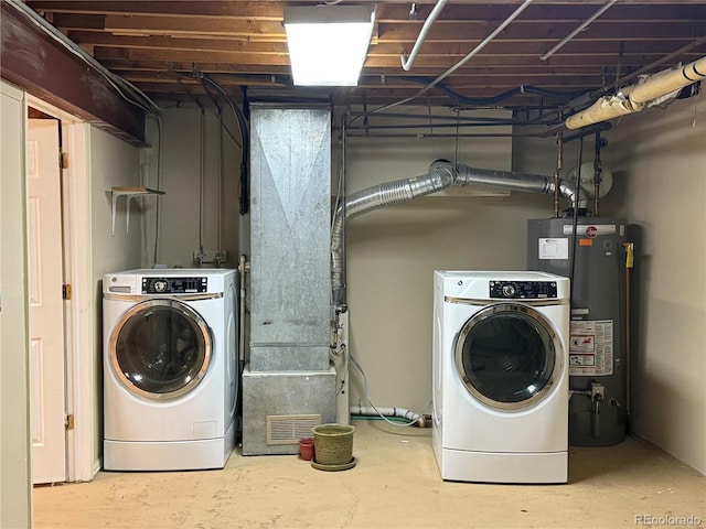 clothes washing area featuring water heater and washer and clothes dryer