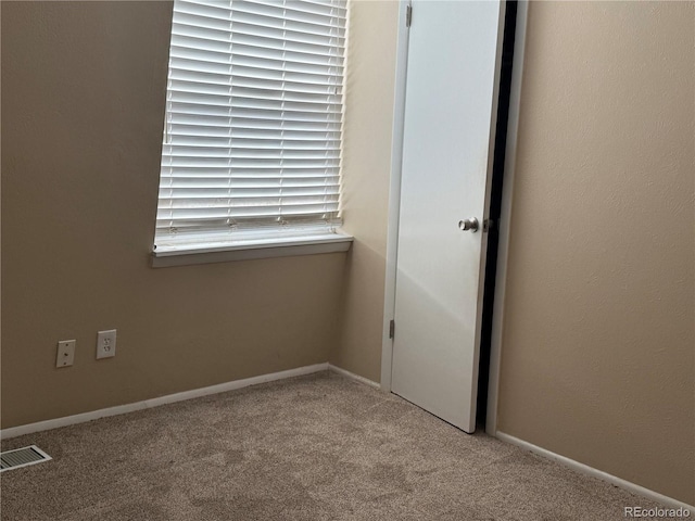 unfurnished room featuring light carpet