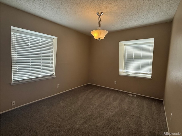 carpeted spare room featuring a textured ceiling